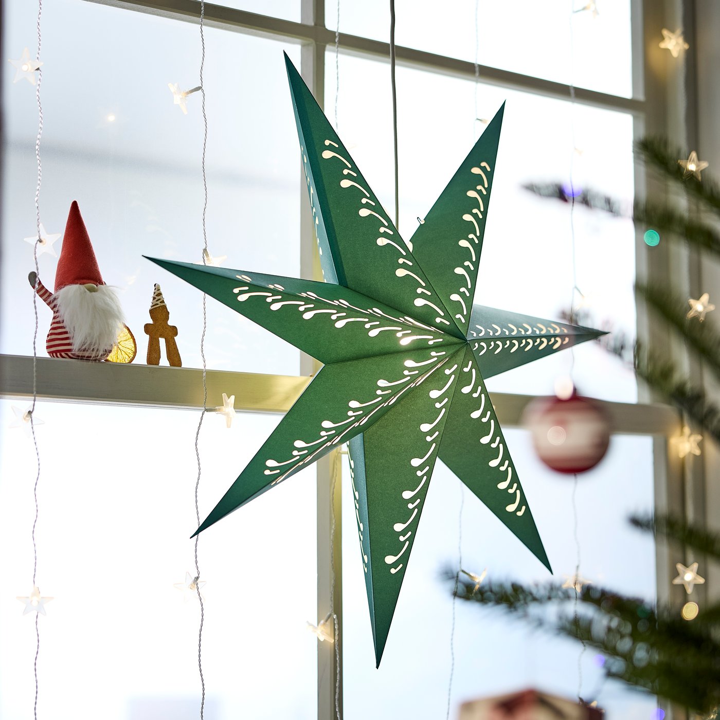 A paper star/green white STRÅLA lampshade in the living room