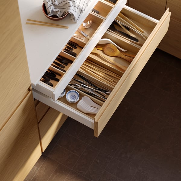 A white MAXIMERA drawer, low in the kitchen