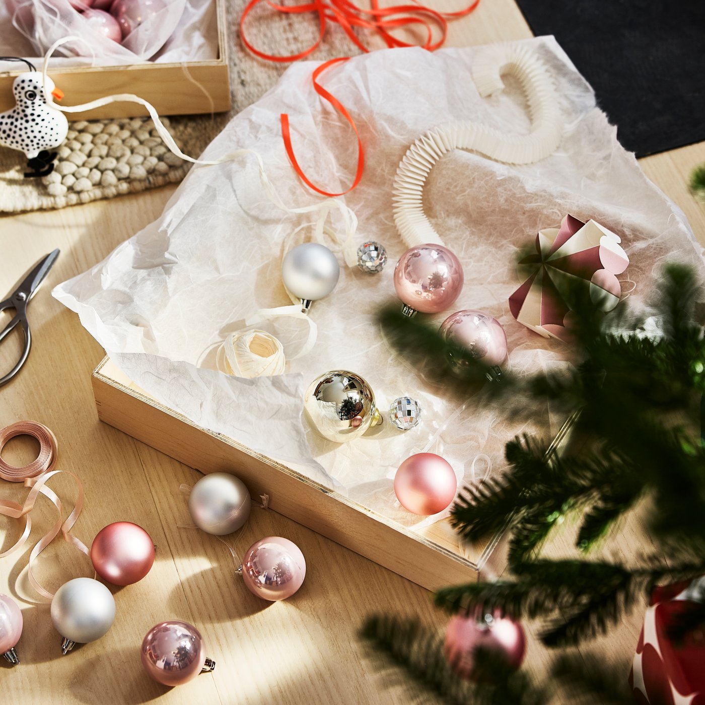 Pink and silver VINTERFINT tree decorations with a white VINTERFINT paper garland inside a shallow tray.