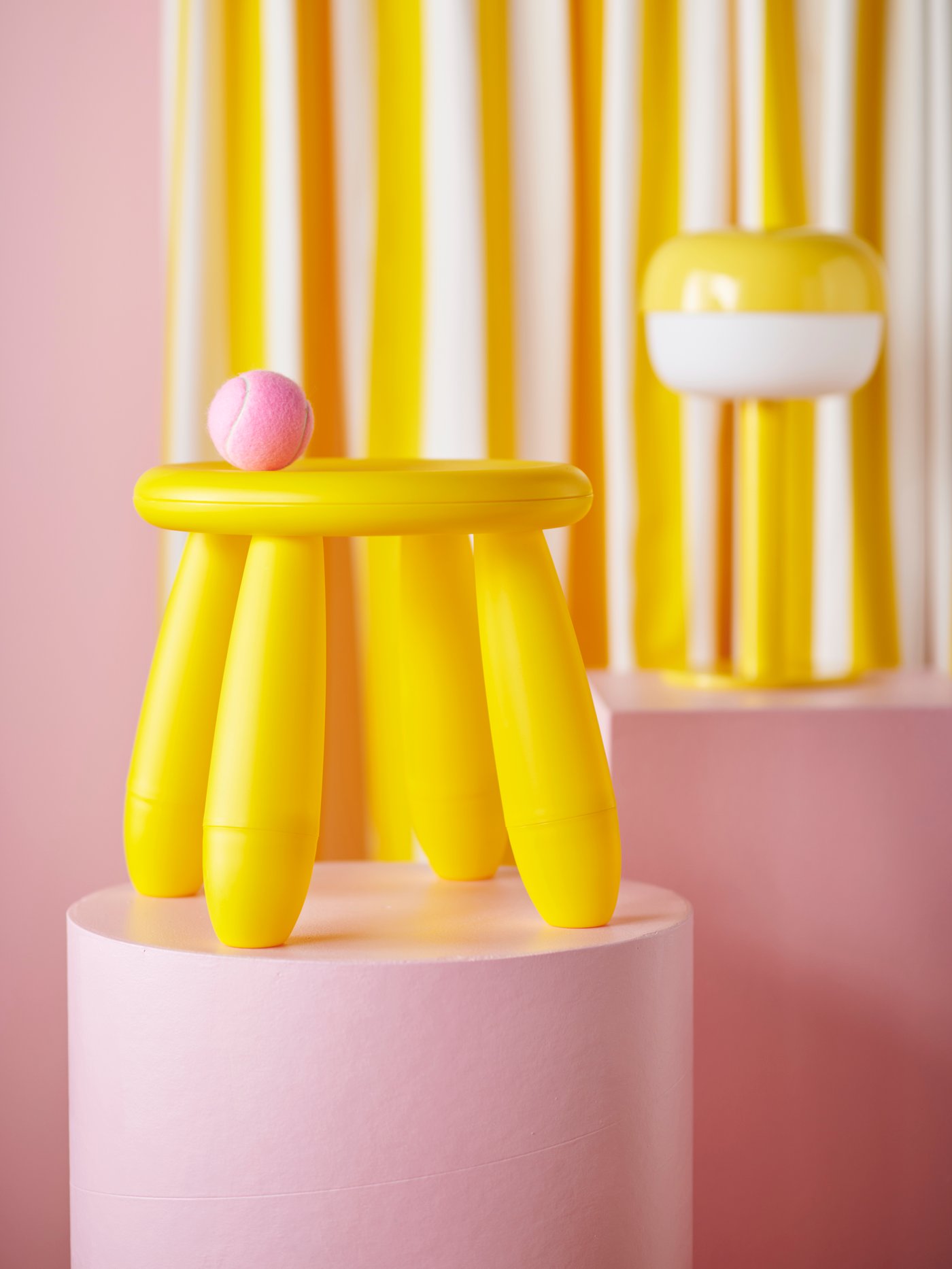 Un piso plástico para niñps de color amarillo de la serie MAMMUT sobre una plataforma rosada.