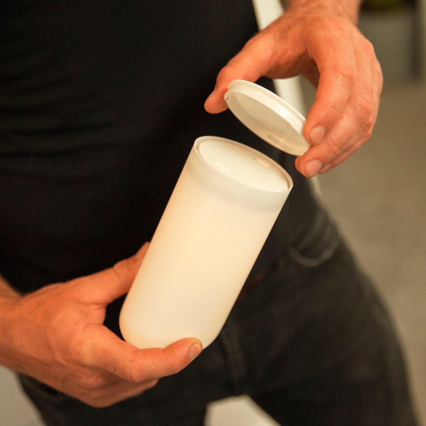 Una mano monta il coperchio della batteria su un cero a LED ÄDELLÖVSKOG.