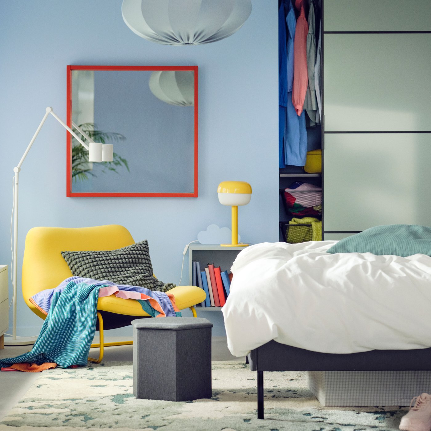 Lit matelassé SLATTUM devant une armoire-penderie intégrée avec portes coulissantes SKYTTA/BOAXEL, près d’un fauteuil SOTENÄS.