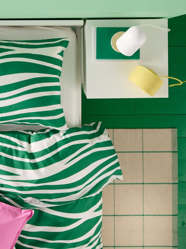 An off-white/green RIDSTIG rug, flatwoven in the bedroom