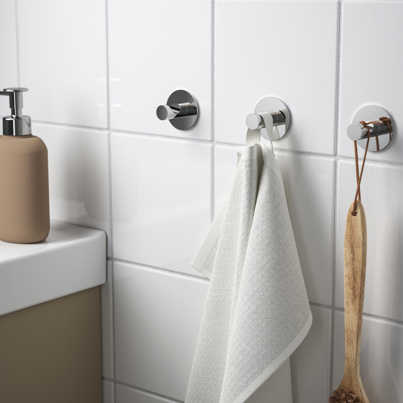 A chrome-plated SKOGHALL hook, self-adhesive in the bathroom