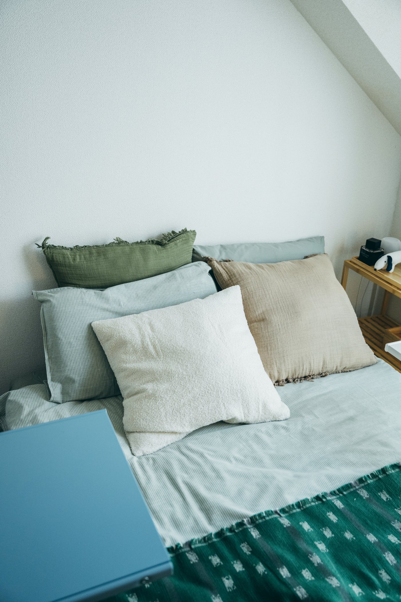 ベッドに複数のクッションが置かれている様子