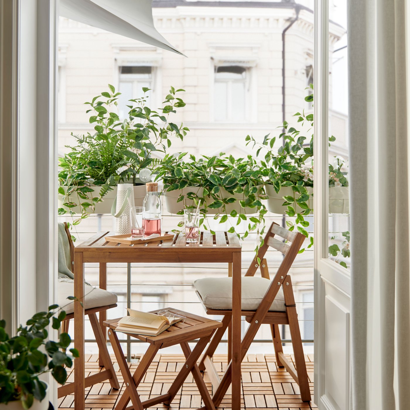 Une table NÄMMARÖ teintée brun clair/beige Kuddarna et deux chaises pliantes, pour l'extérieur