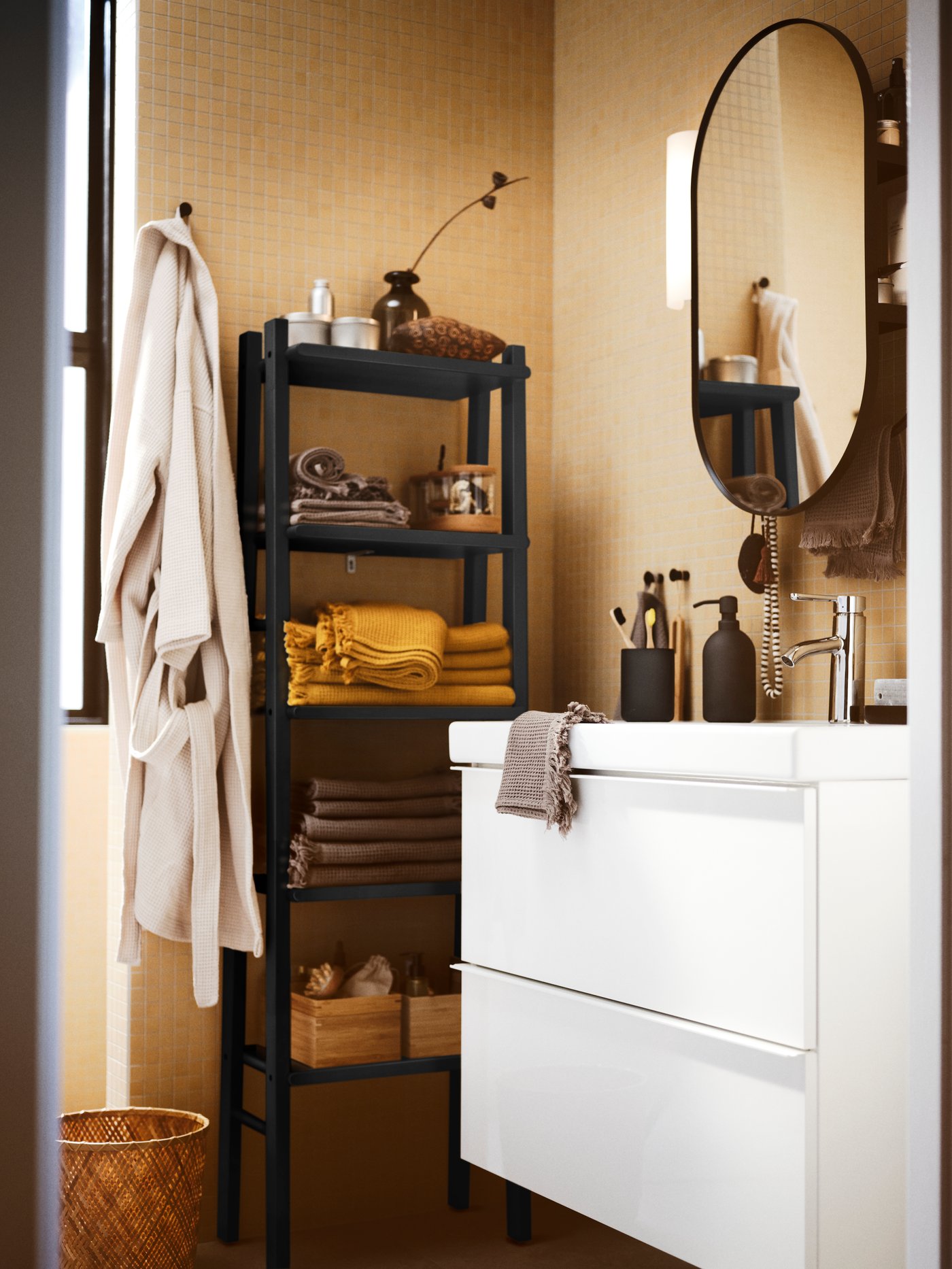 A bathroom with a mirror above a high-gloss white GODMORGON wash-stand with two drawers and a birch towel stand with towels.