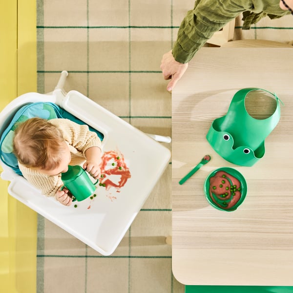 Bright green frog-themed four piece MATA baby tableware set with bib, bowl, sippy cup and spoon.