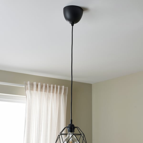 Une monture électrique HEMMA en noir suspendue au plafond.