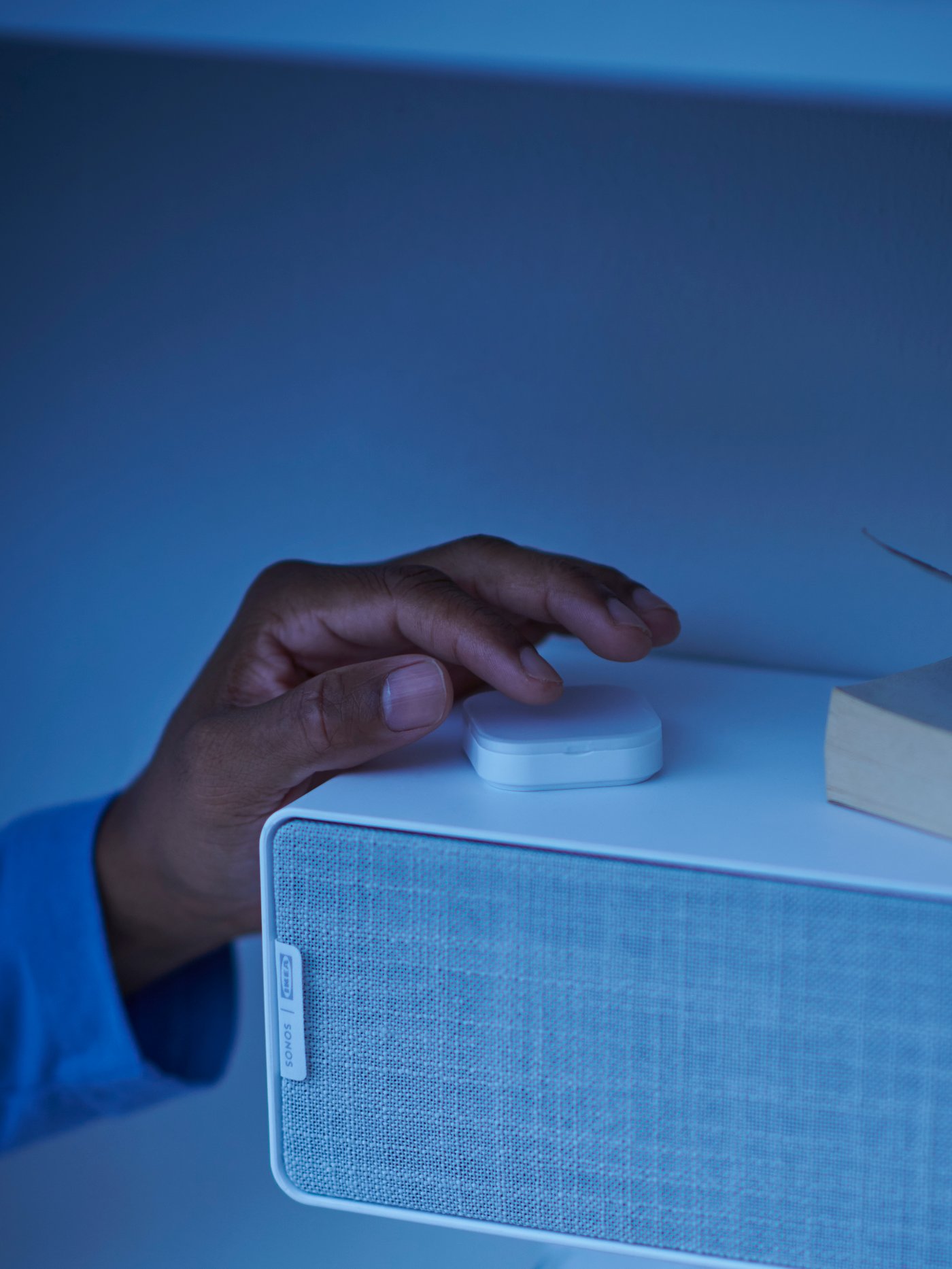 hand adjusting volume on speaker