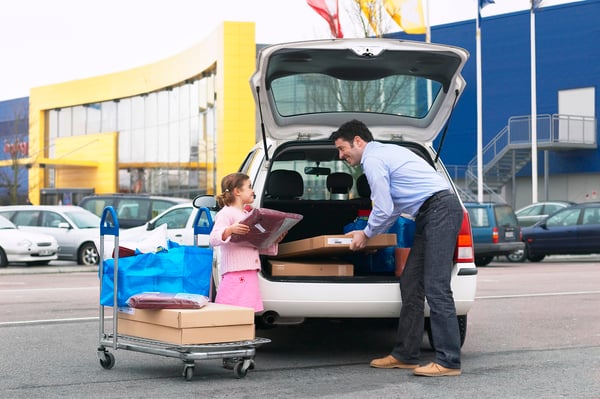 Image d'un parent avec son enfant en train de charger le coffre de sa voiture