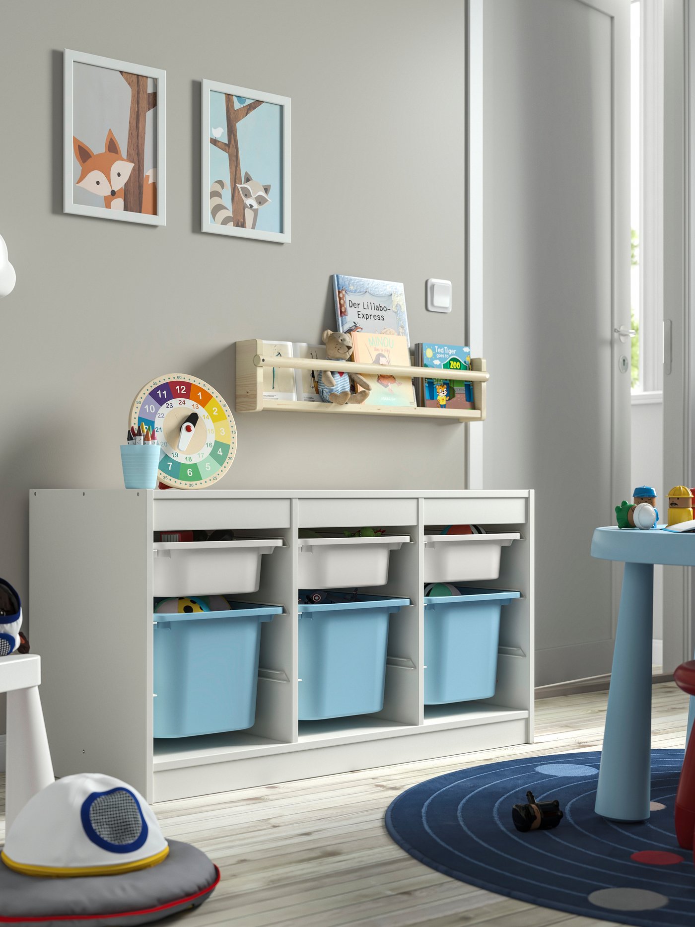 A white white/light blue TROFAST storage combination with boxes in the childrens room