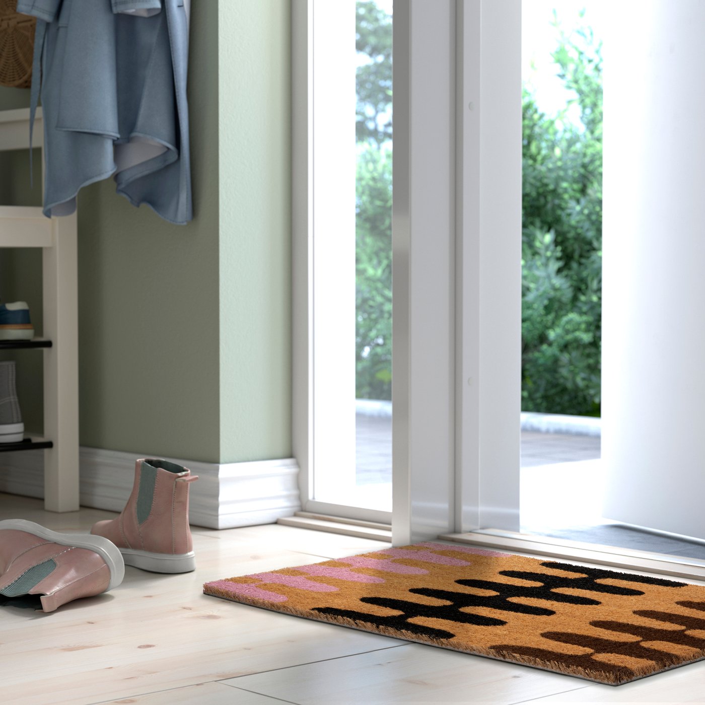 Dörröppning mot en uteplats, en dörrmatta med mönster, rosa stövlar och en hylla med kläder och skor.
