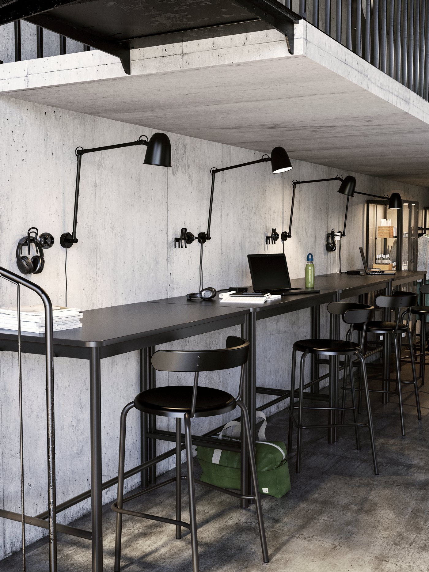 A low-ceilinged co-working space with workstations along a bar, each with a SKURUP work/wall lamp and YNGVAR bar stool.