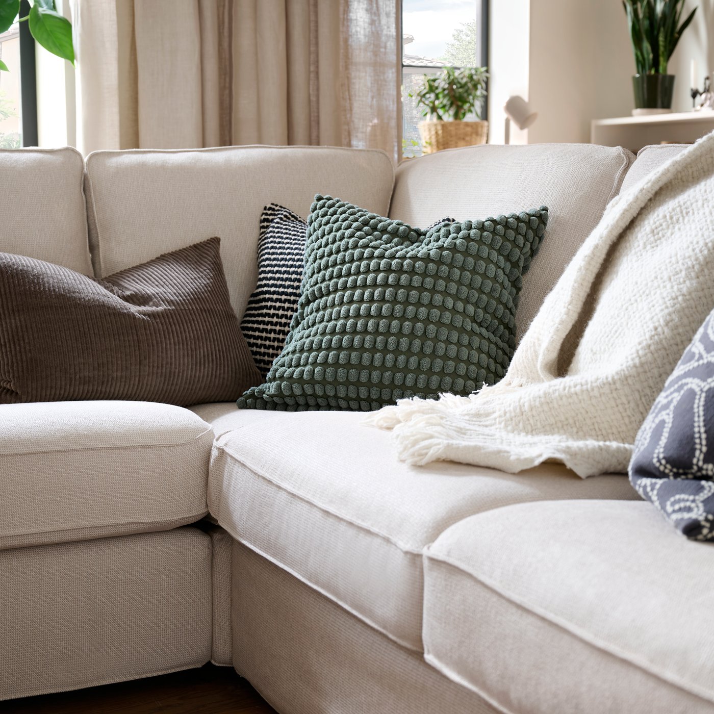 An anthracite/off-white GULDFLY cushion cover in the living room
