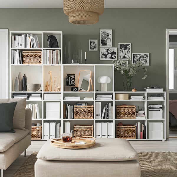 Une lampe de table TONVIS et un tourne-disque sur une étagère KALLAX blanche remplie de disques vinyles et divers autres petits rangements.