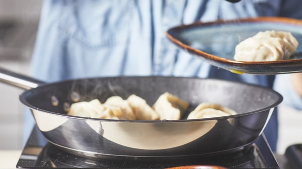 フライパンで餃子を調理している