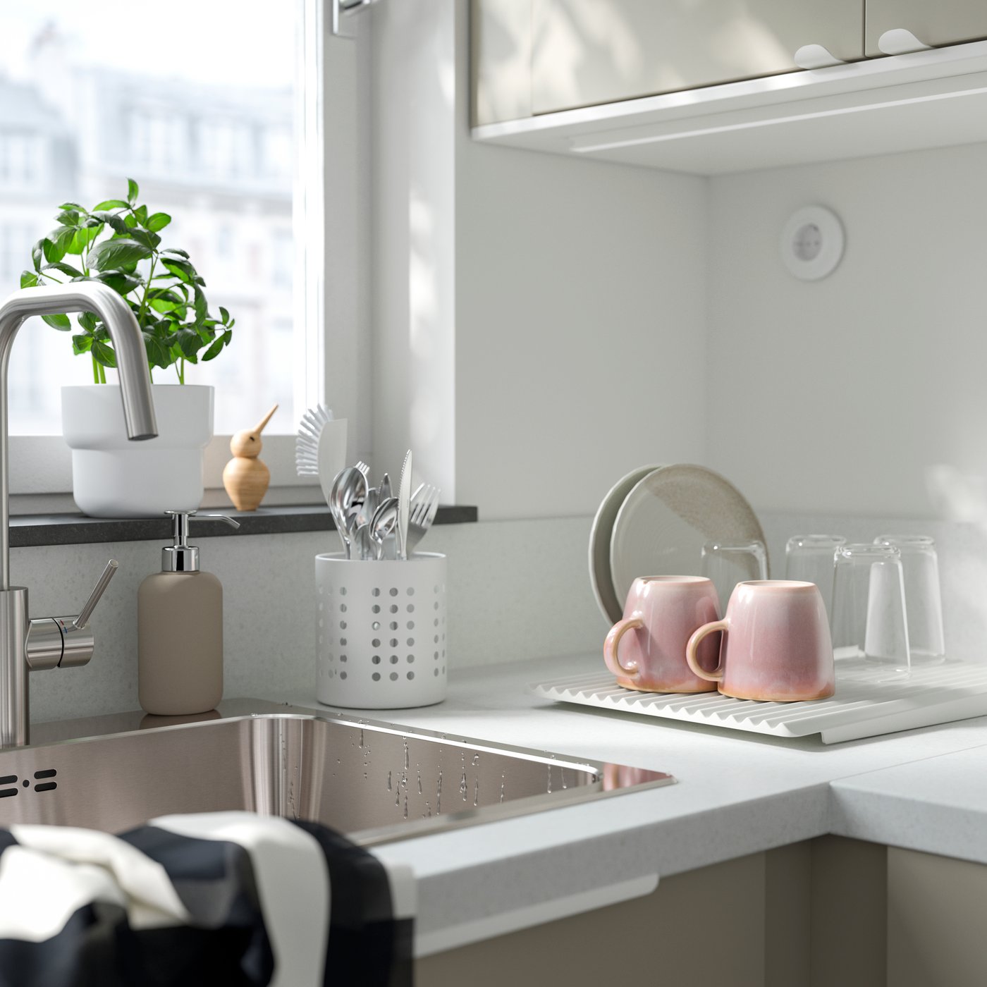 ORDNIEscurrecubiertos ORDNING blanco colocado junto en una cocina con trastes lavados.