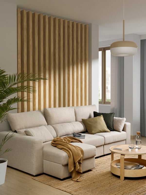 Ein hellbeiges ESKILSTUNA 3-Sitzer-Sofa mit Chaiselongue.