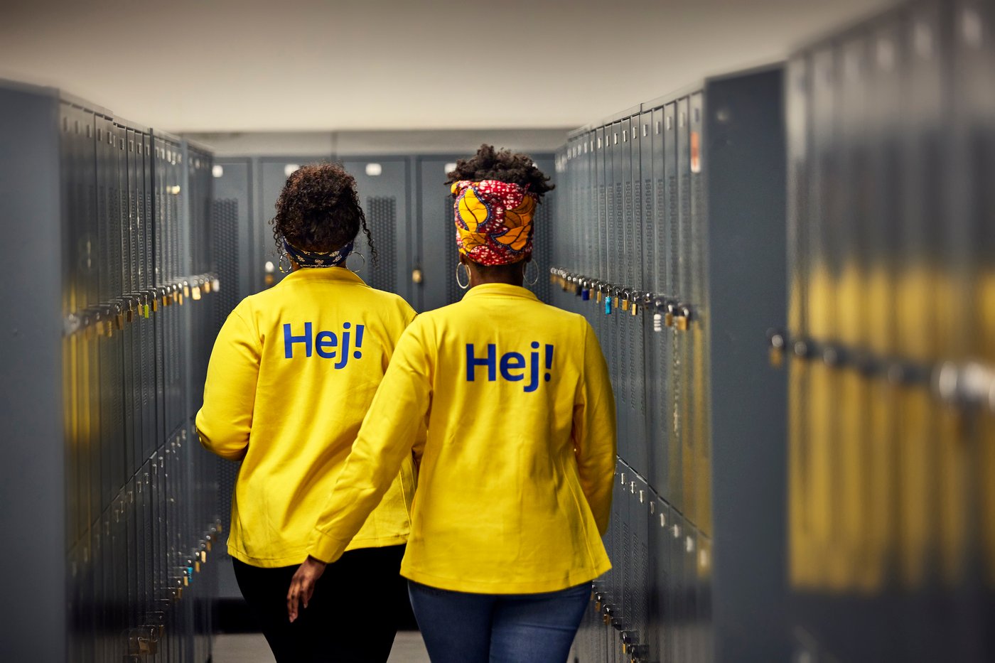 Dos colaboradoras de IKEA andan en un pasillo del area de colaboradores con unas taquillas