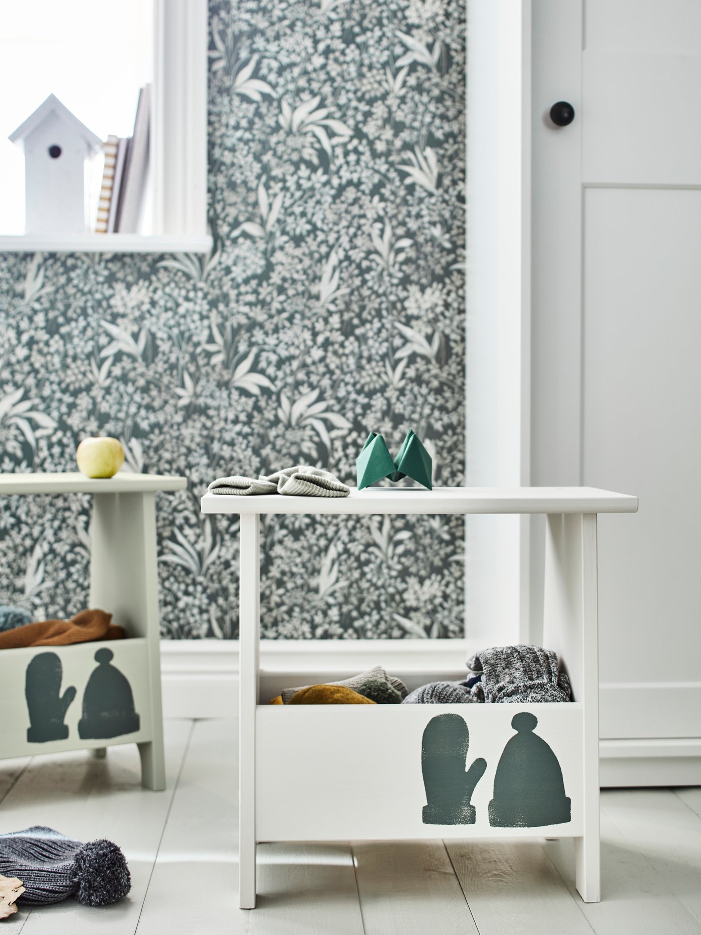 Un pasillo con varios taburetes beige con almacenaje de pino macizo y un armario blanco con puertas correderas.
