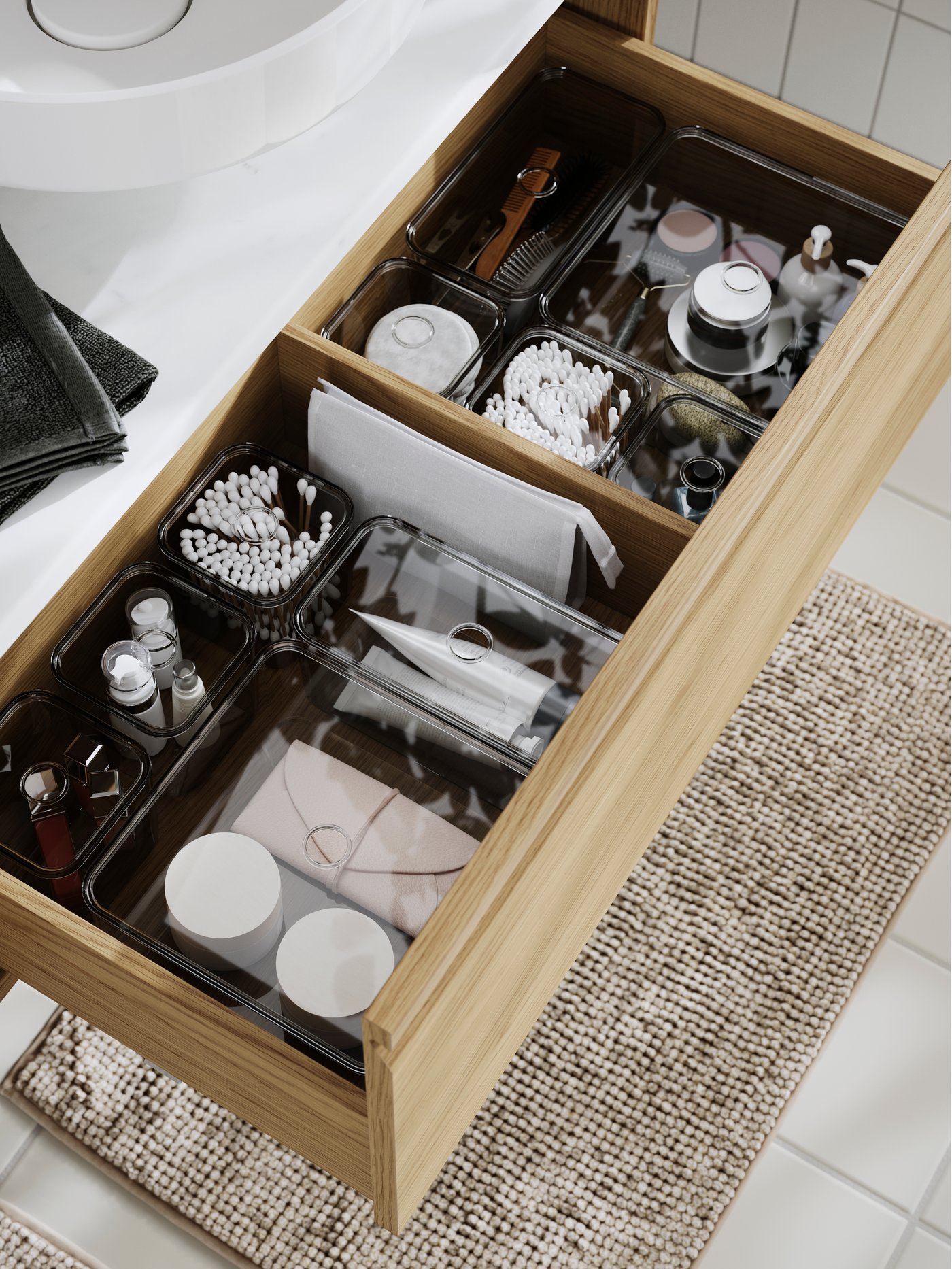 The ÄNGSJÖN wash-stand with drawer, filled with toiletries, cotton buds, towels, and skincare containers, organised neatly.