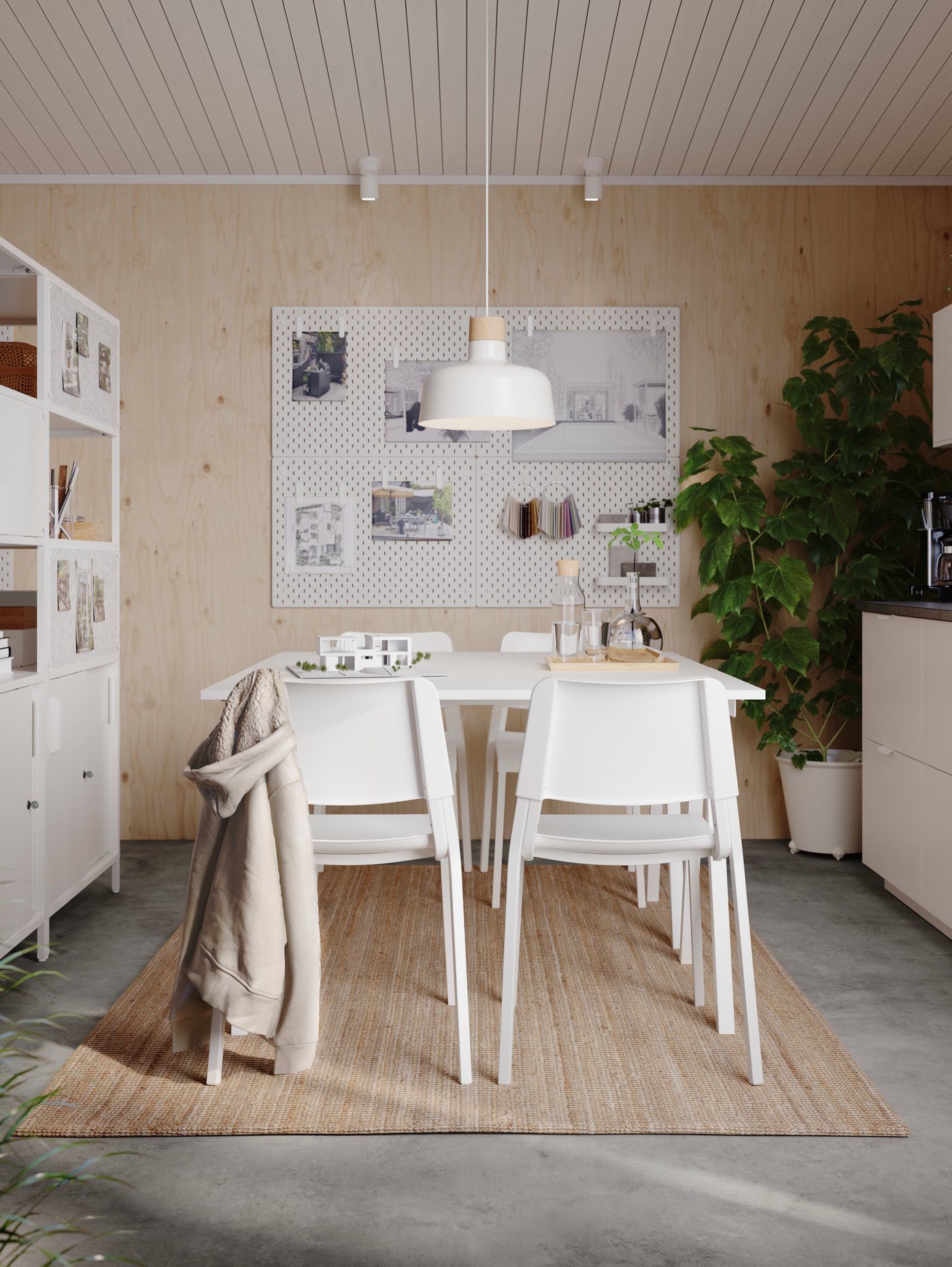 Sillas TEODORES alrededor de una mesa blanca en un estudio luminoso. Una lámpara de techo colgada sobre la mesa y un tablero en la pared.