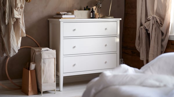 A beige PURRPINGLA laundry bag with stand in the bedroom