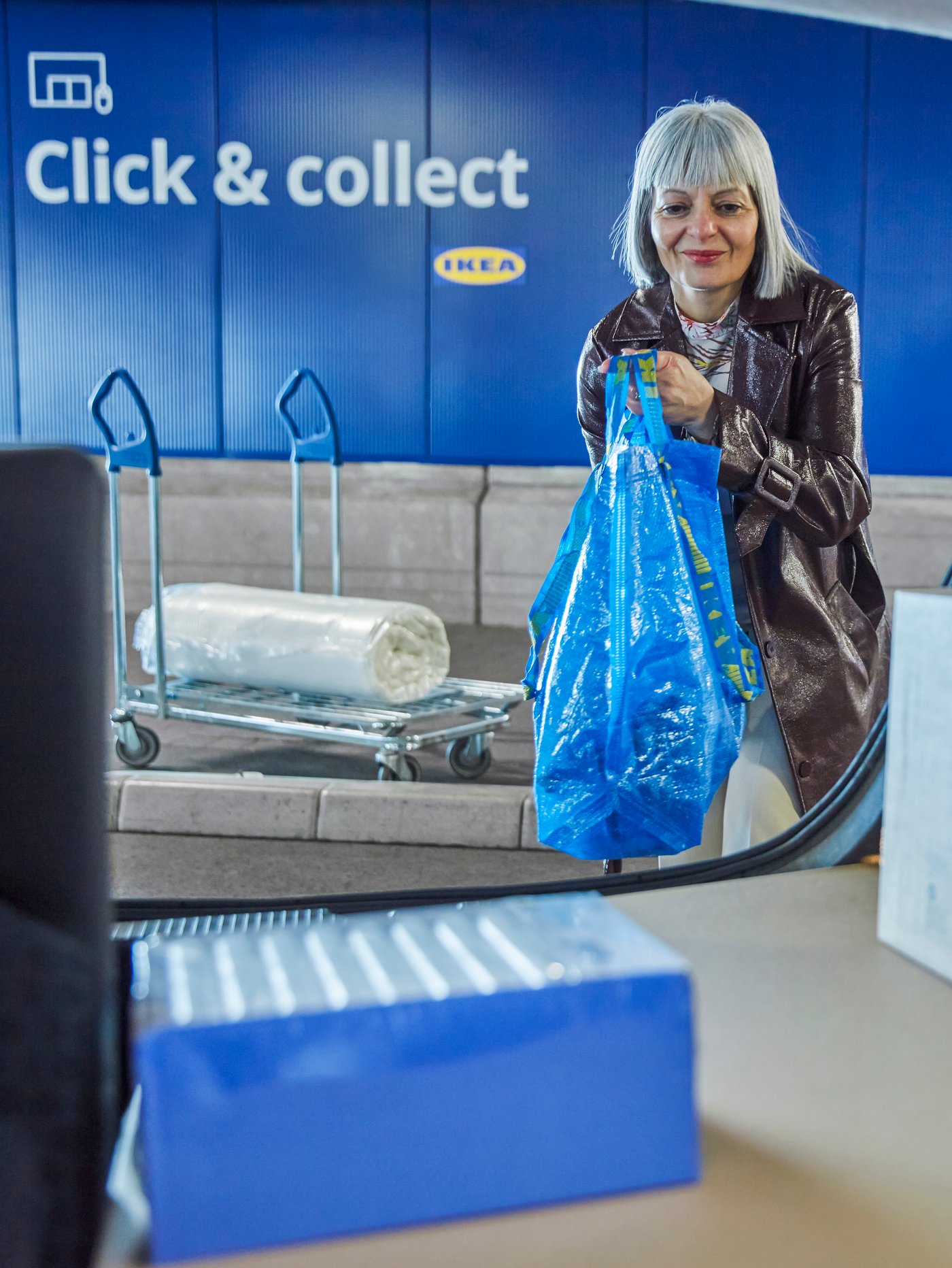 Žena unosi IKEA proizvode u gepeg svojih kola.