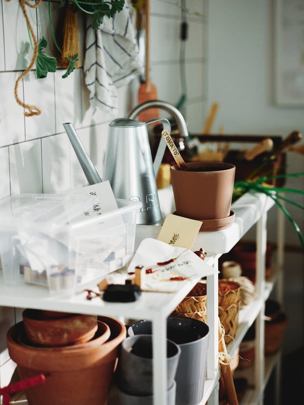 Gardening supplies on a white shelving unit.