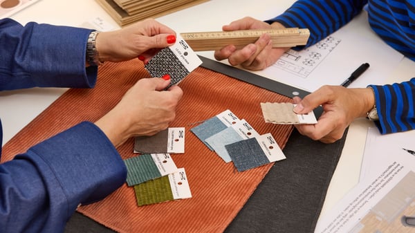 Close-up of an IKEA interior designer showing textile samples to a customer.