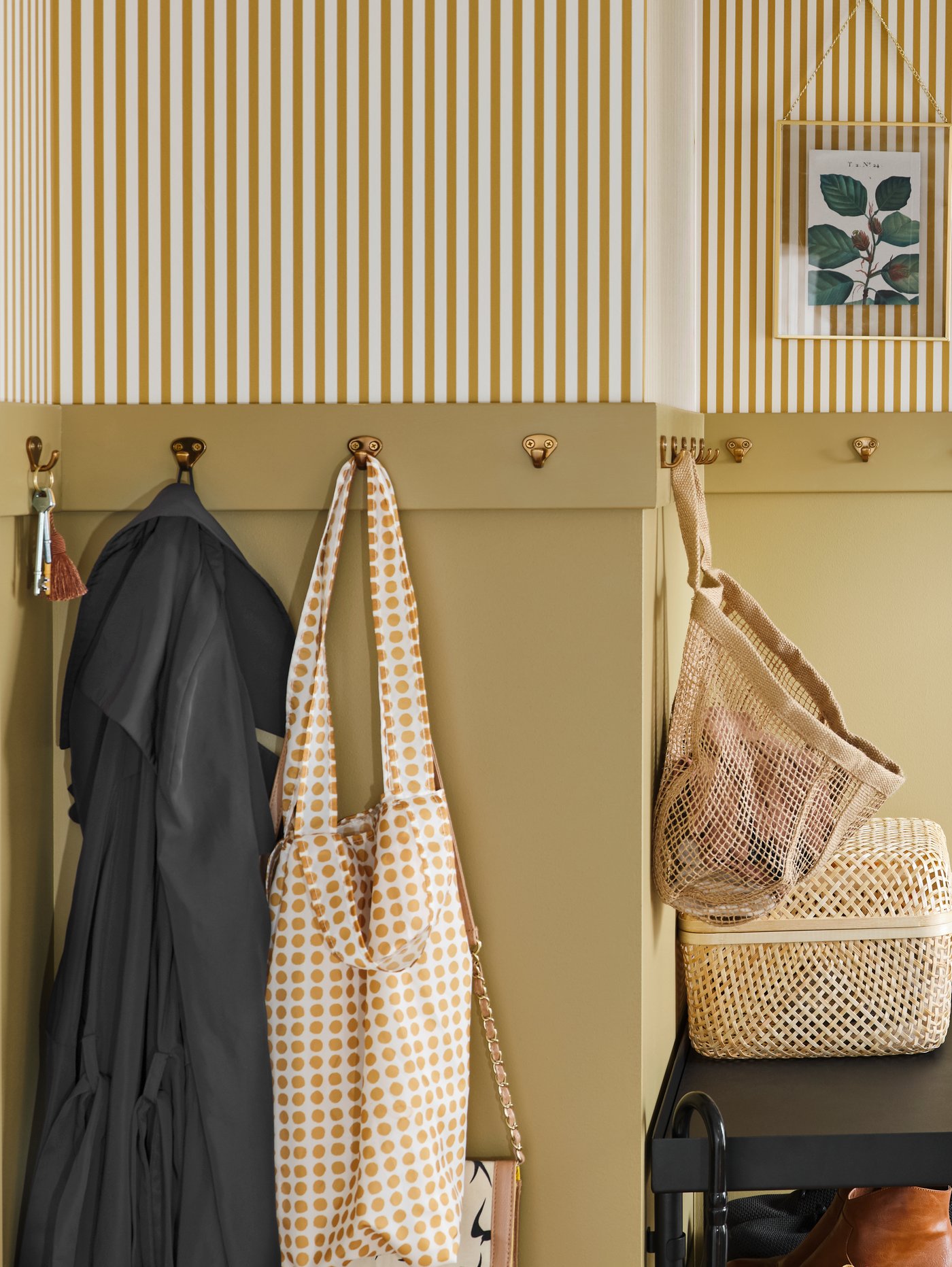 A row of KVAST hooks go around the wall of a hallway. Keys, clothes and a LUSTIGKURRE bag hang from the hooks.