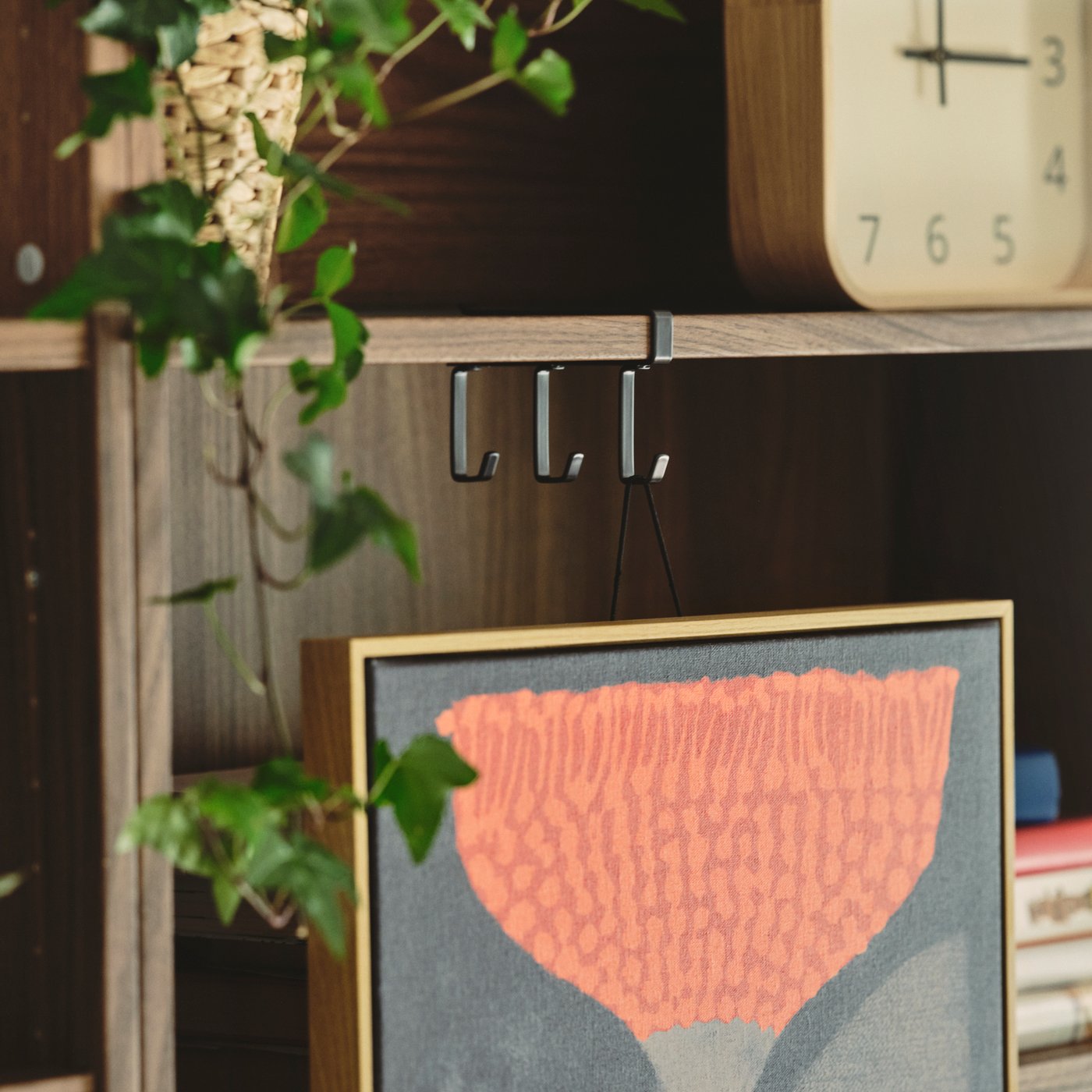 A living room features a brown BILLY bookcase with books, decorative items, and plants, creating a warm and inviting space.