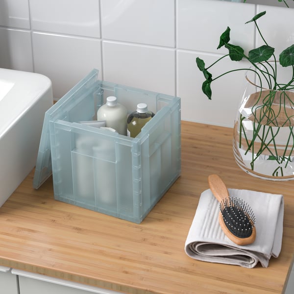 A transparent grey-blue PANSARTAX storage box with lid in the bathroom