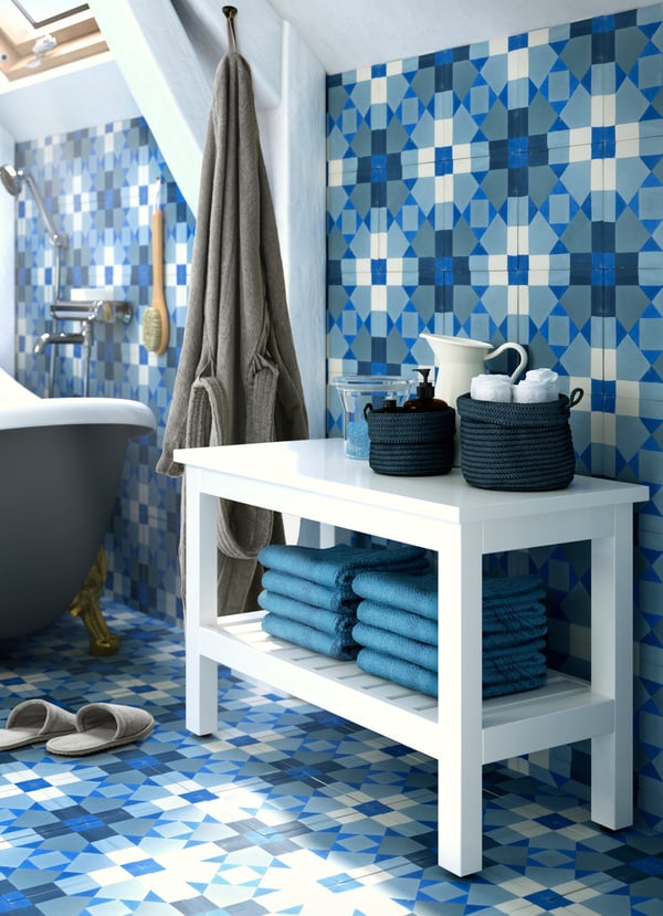 Un bagno con una panca HEMNES bianca con spazio per gli asciugamani.
