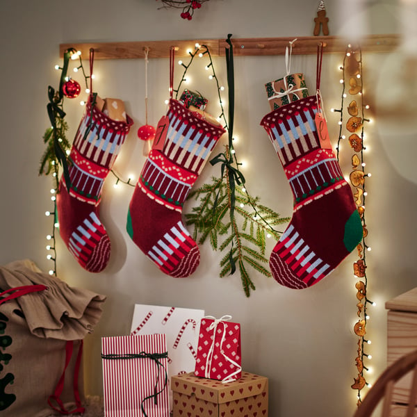Julstrumpor upphängda med ljusslinga och granris.