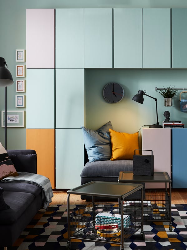 A living room area with multi-colored IVAR storage units on the wall.