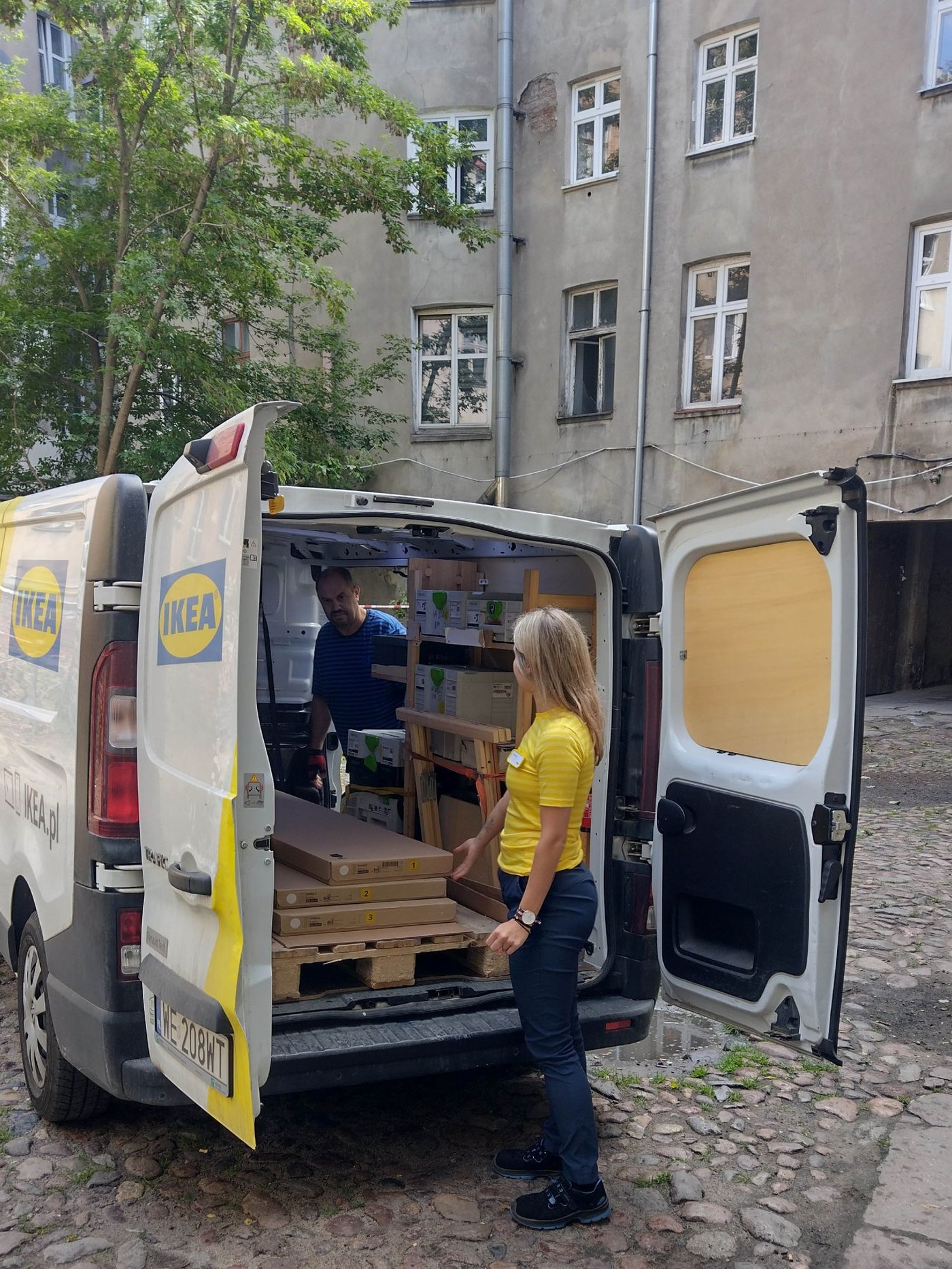 Pracownicy IKEA przy samochodzie z transportem mebli