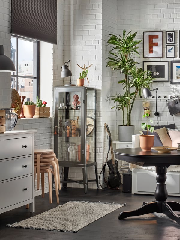 A dark grey FABRIKÖR glass-door cabinet in the living room