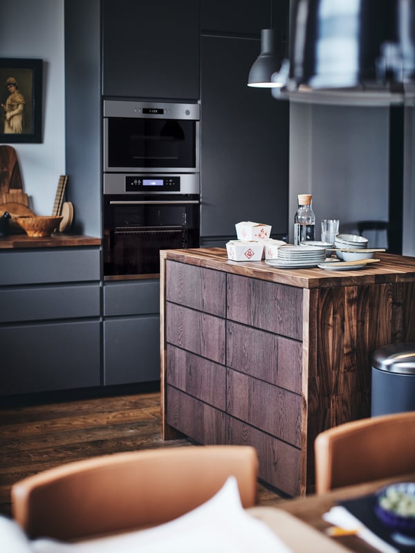 A METOD kitchen with a wooden kitchen island with plates and takeaway food containers on top.