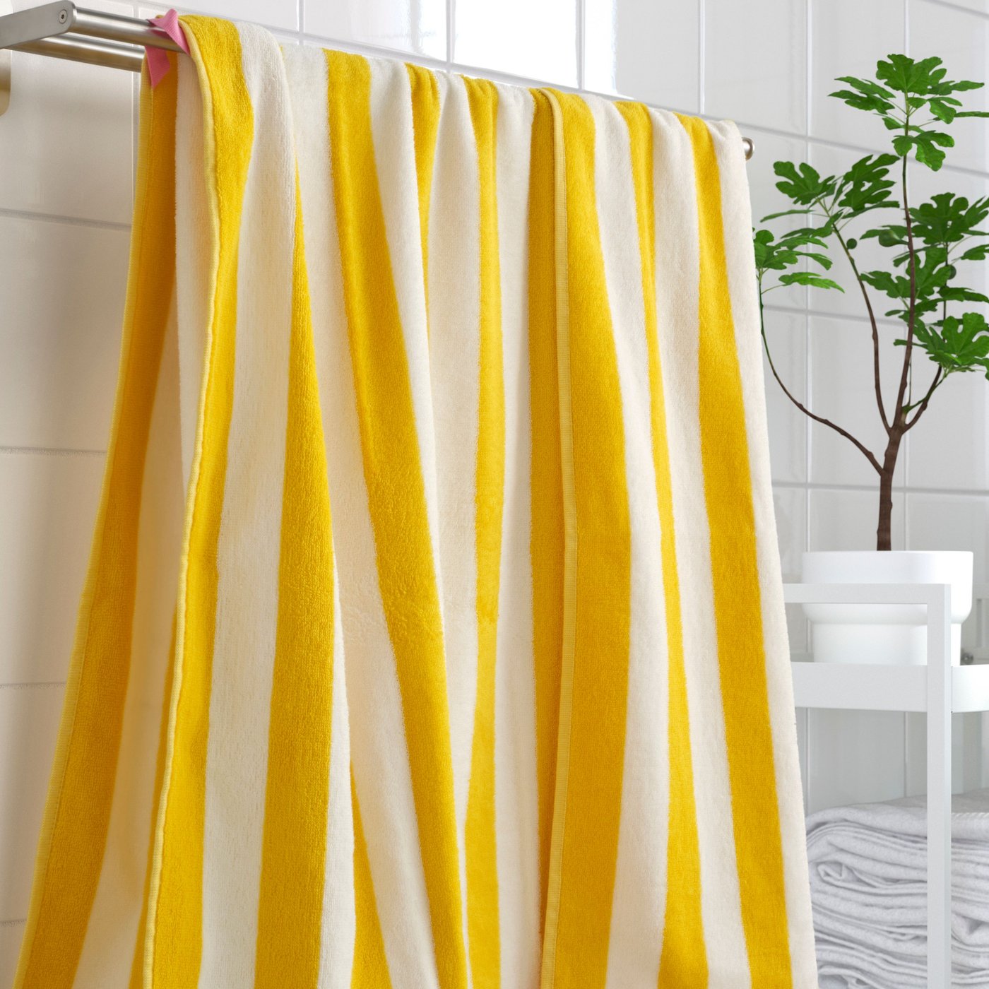 A white/yellow striped SLÅNHÖSTMAL bath sheet in the NA