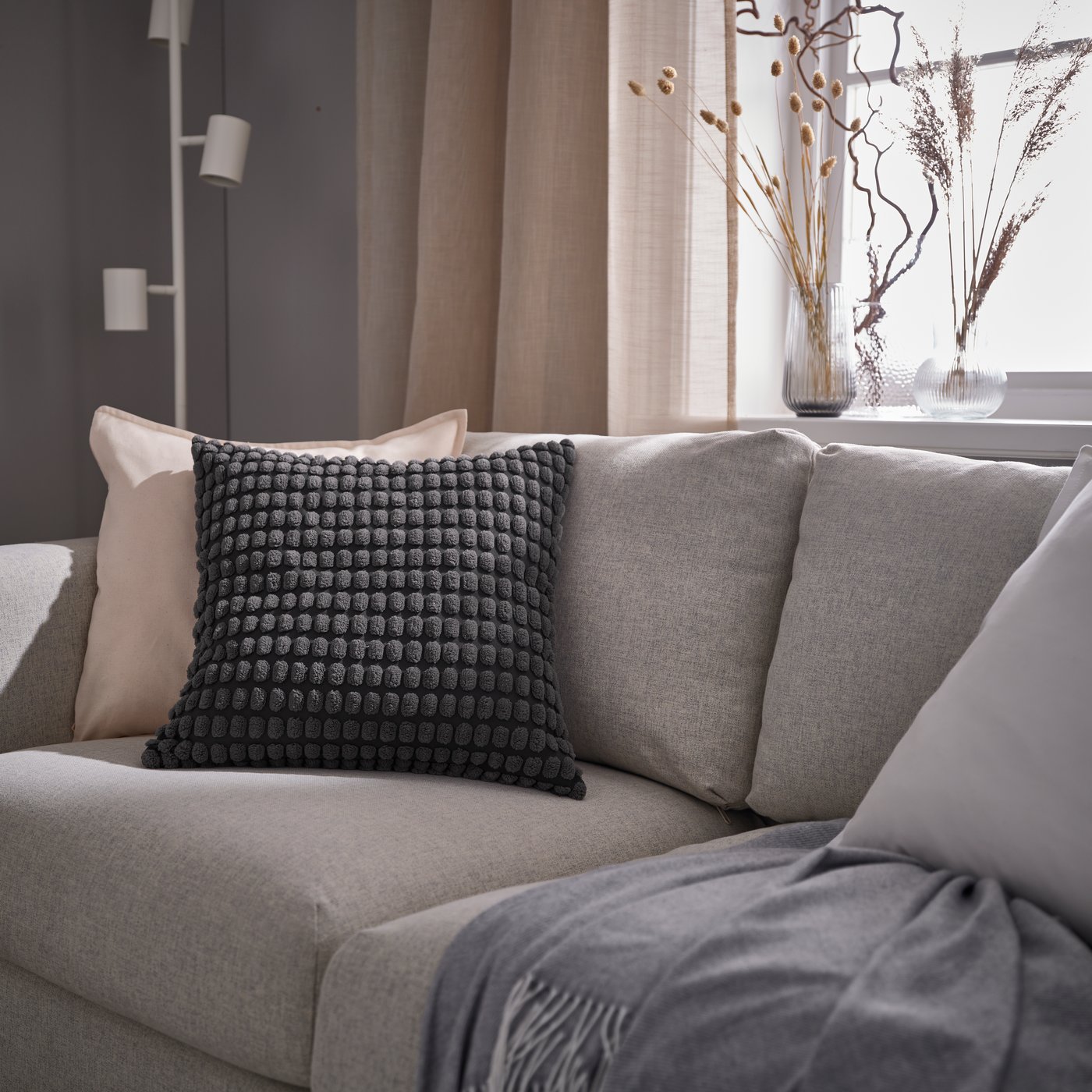 An anthracite SVARTPOPPEL cushion cover