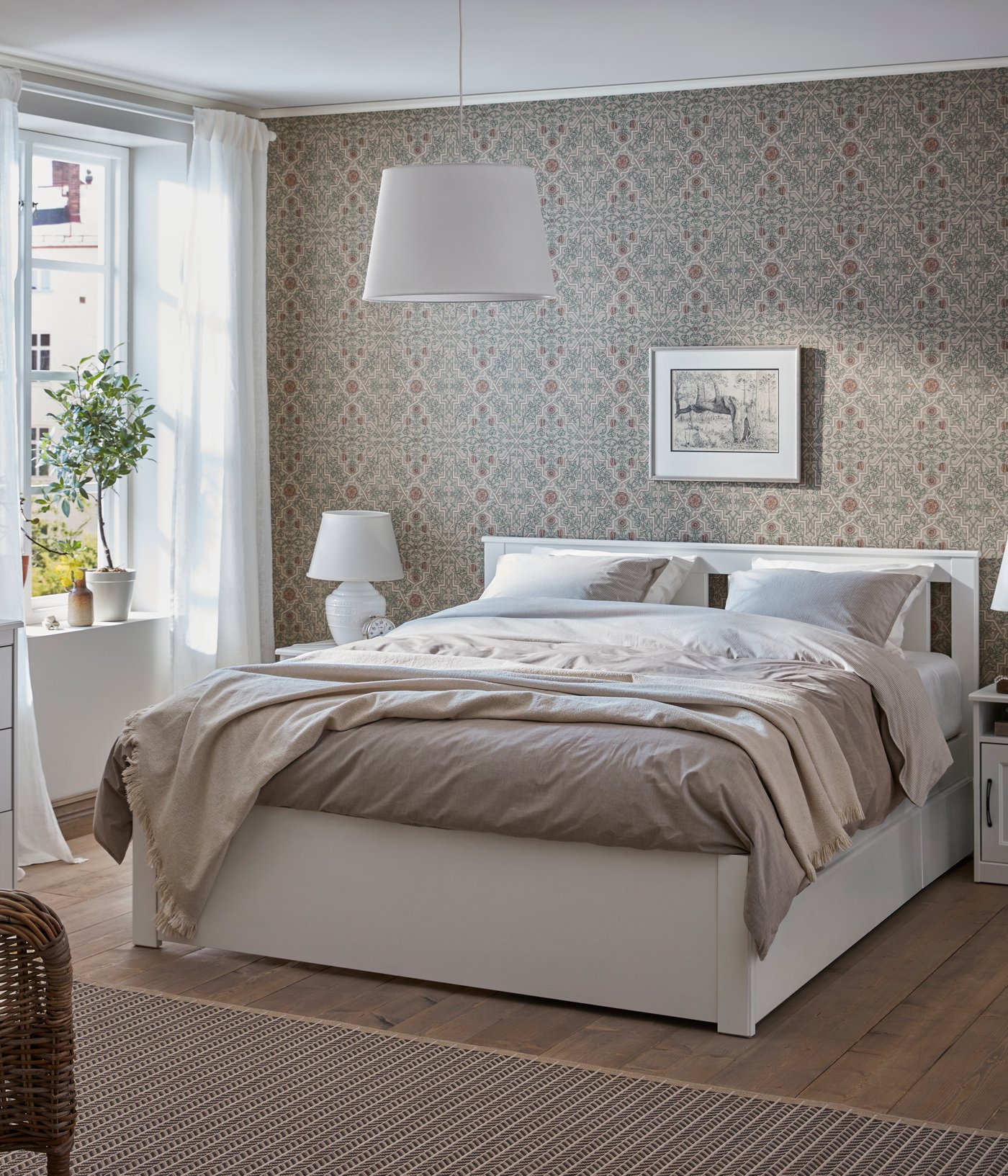 Un letto SONGESAND bianco con 2 contenitori in camera da letto.