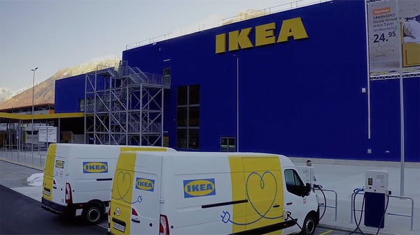 Two IKEA delivery EV trucks sit outside an IKEA store.