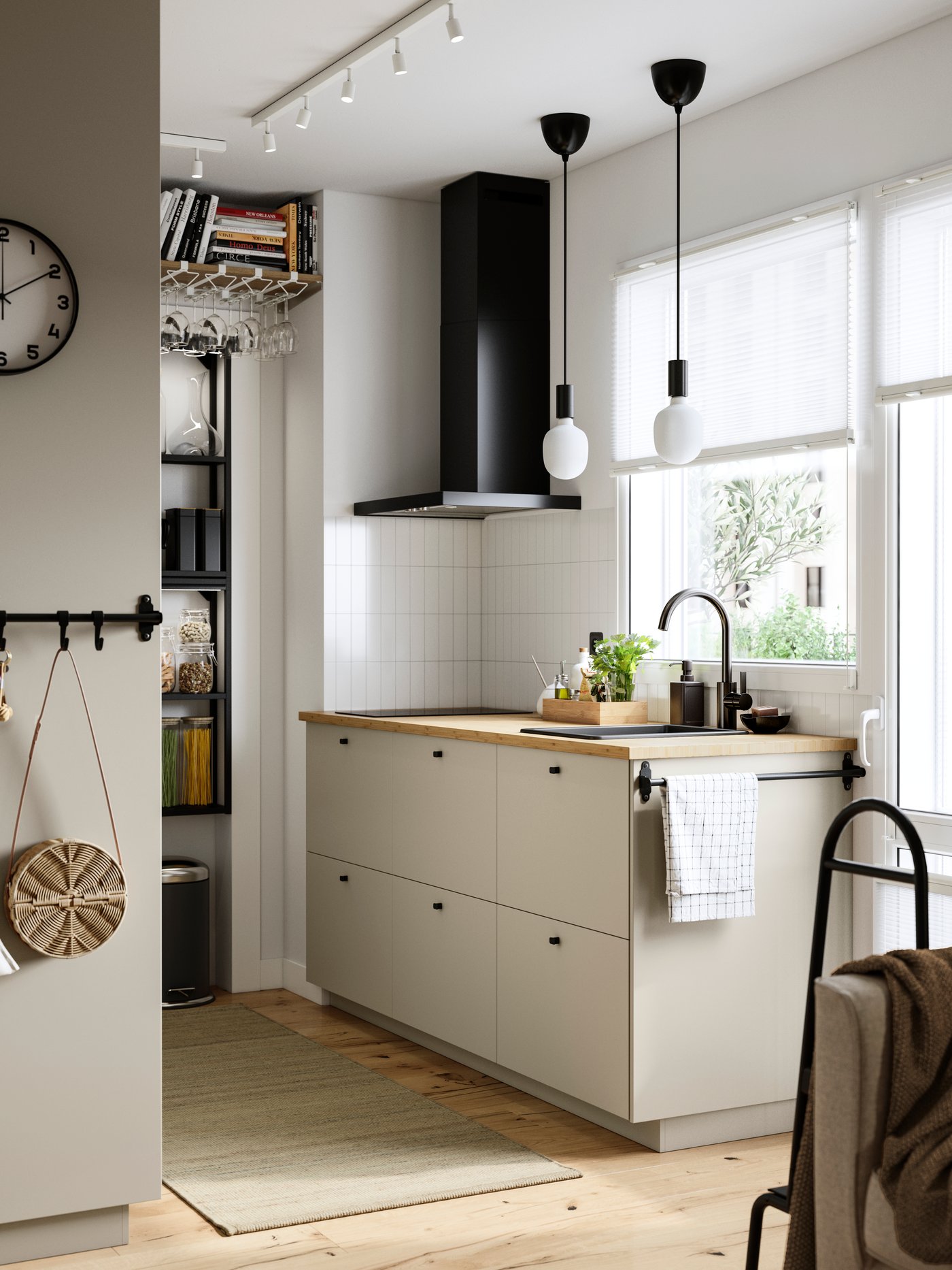 Et køkken har beige HAVSTORP fronter, en ENHET vægramme med hylder og en sort vægmonteret MATÄLSKARE emhætte.