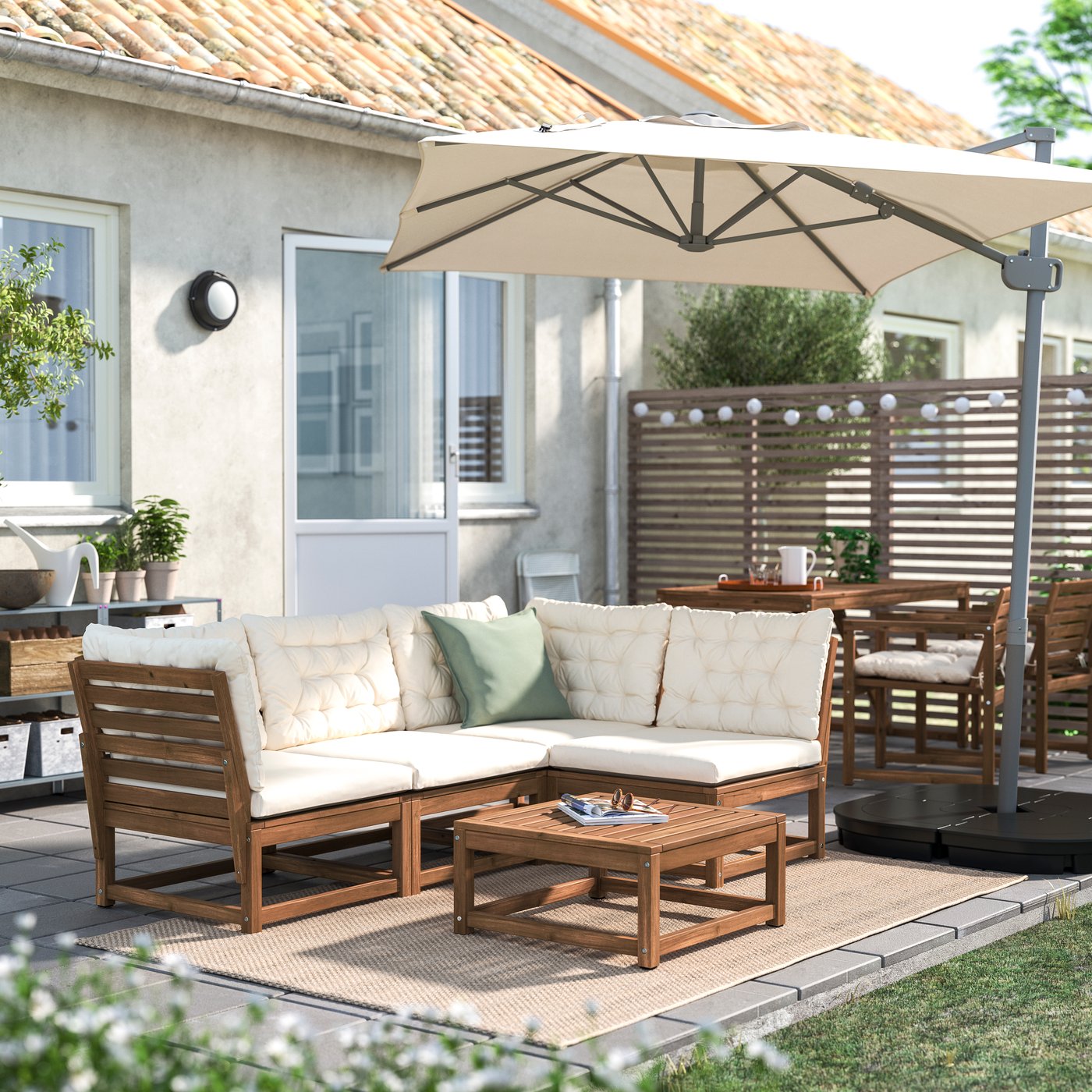Set modular de sofá NÄMMARÖ marrón claro para exterior en un jardín.