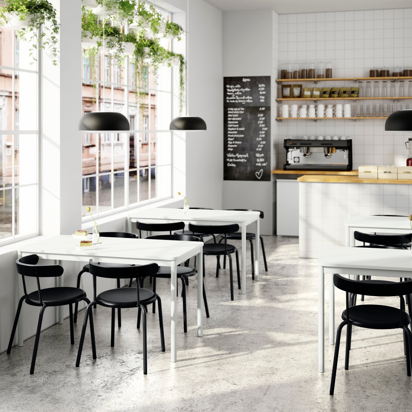 A café with white TOMMARYD tables, anthracite YNGVAR chairs, a counter area and a large black-and-white menu board.