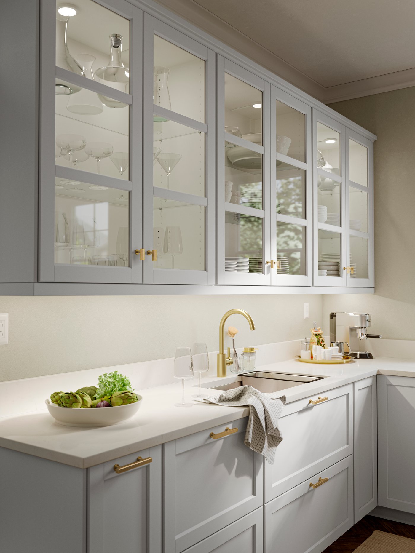 Light gray kitchen with glass-front cabinets, gold fixtures, and a white countertop.