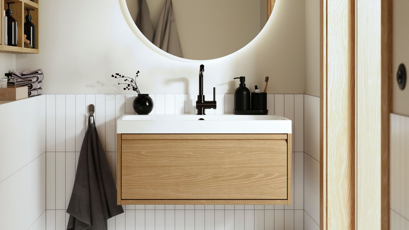 A bathroom with a white high-gloss wash-stand with two drawers and a grey countertop with two white wash-basins and a mirror.