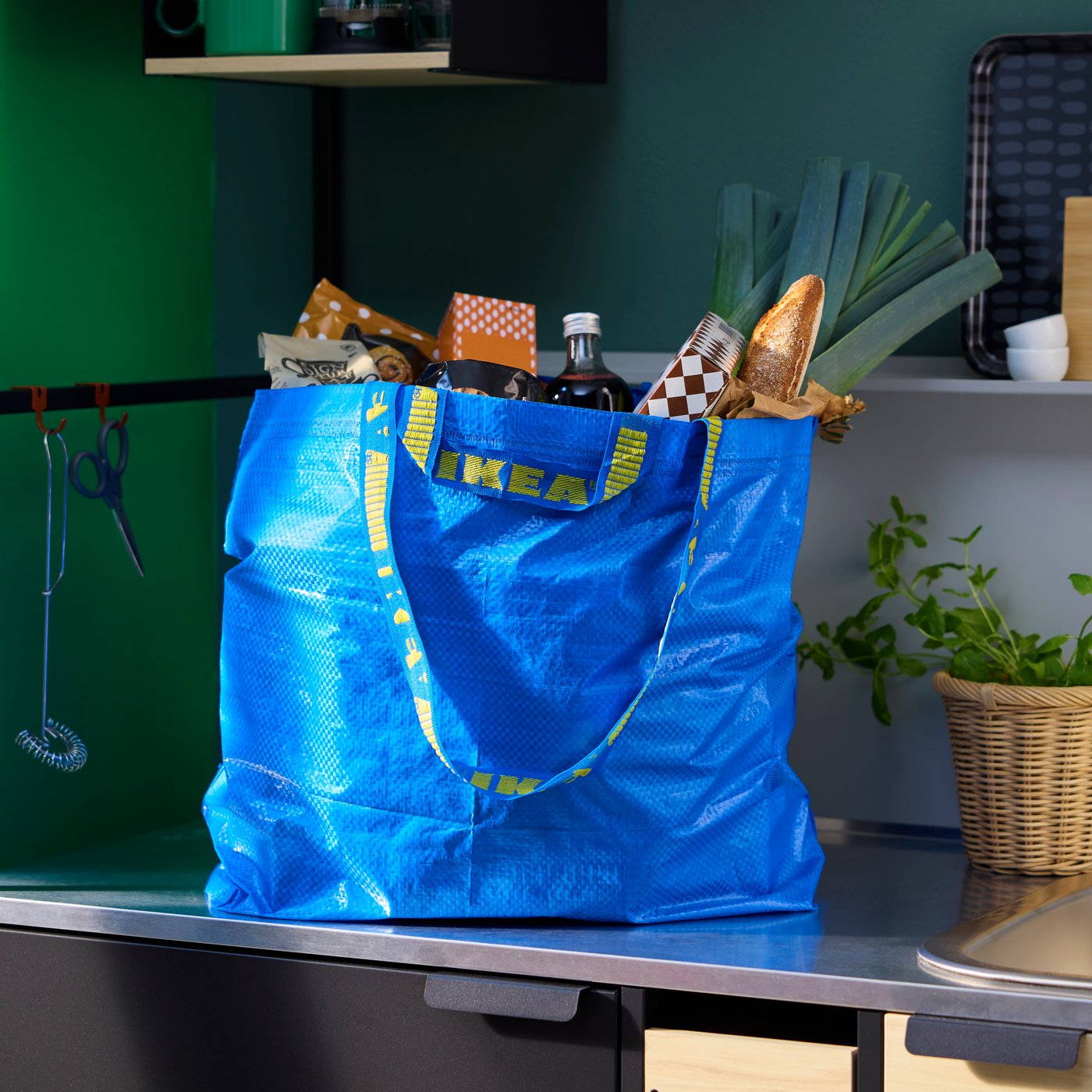 Un sac FRAKTA rempli est posé sur le plan de travail d'une cuisine.